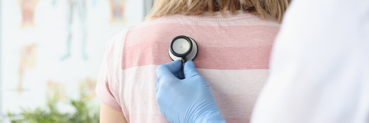 Doctor therapist listens to patient breathing with stethoscope