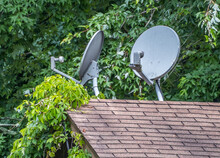 Old Satellite Dishes On A Roof
