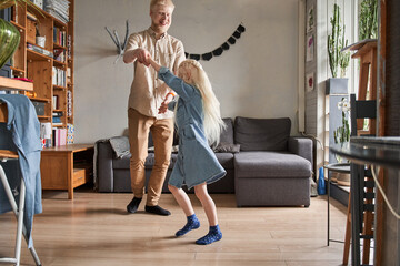 Wall Mural - Girl with dad having fun, laughing and enjoying leisure at home