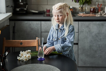 Wall Mural - Girl standing at the table and preparing to putting flowers at the vase