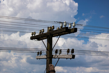 Electric pole on a background of blue sky with white clouds