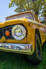 Canvas Print - Vertical shot of an old style yellow car front light detail