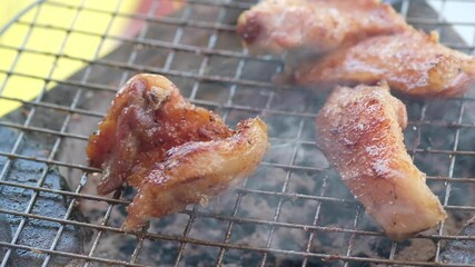 Wall Mural - Pork neck grilling over charcoal on a steel grill with smoke