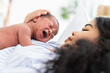 © amorn - Newborn baby crying on mother's. Mother take care her African American infant on hands with kindness. family, love, happy and new life concept