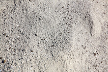 The Texture Of Fine Gray Sand Illuminated By The Sun