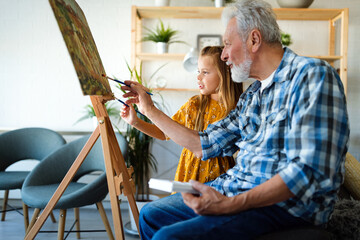 Wall Mural - Happy smiling grandfather and grandchild painting together. Family, generation, happiness concept