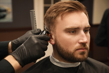 Wall Mural - Professional hairdresser working with client in barbershop