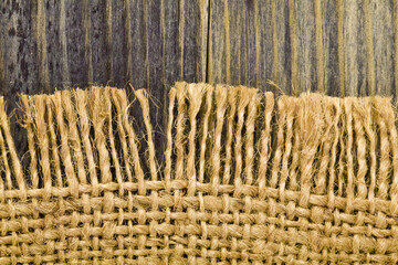 Wall Mural - Rough fabric texture on a wooden background.