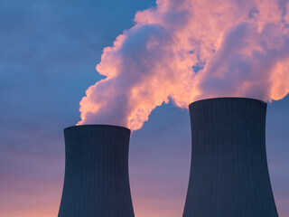 Nuclear power plant against sky at sunset