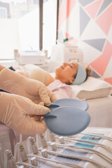 Poster - Vertical shot of a female physical therapist holding plastic pads in the spa