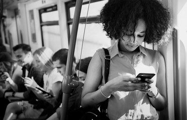 Wall Mural - Young woman using a smartphone in a subway