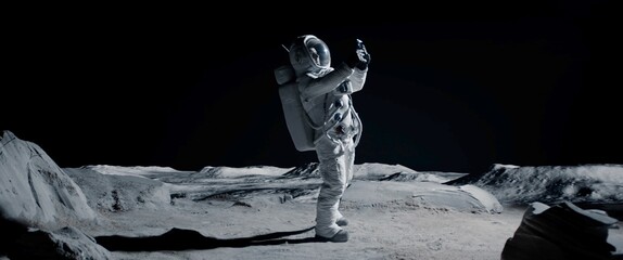 wide male actor in astronaut suit making selfie on a moon lunar movie shooting set. shot with 2x ana