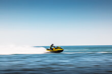 Summer Fun By The Sea, Girl Ride A Jet Ski In Spray Of Water