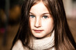 Portrait of a teenage girl in a light sweater with dark hair and blue eyes, close-up, full face