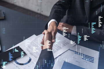 Wall Mural - A handshake symbolize a capital market transaction to proceed profit in stock trading. Financial hologram chart over the table with the document. Women in business concept.