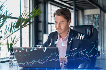 handsome businessman in suit at workplace working with laptop to optimize trading strategy at corpor