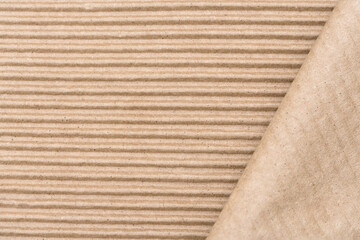 Corrugated cardboard kraft paper texture background with a folded edge of the sheet, copy space