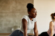 © Drazen - Young athletic black woman doing relaxation exercises while warming up at health club.