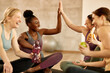 © Drazen - Happy athletic women giving high-five while relaxing after exercise class at health club.
