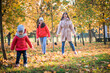 © irishasel - Mother and her child girl playing together on autumn walk outdoors.