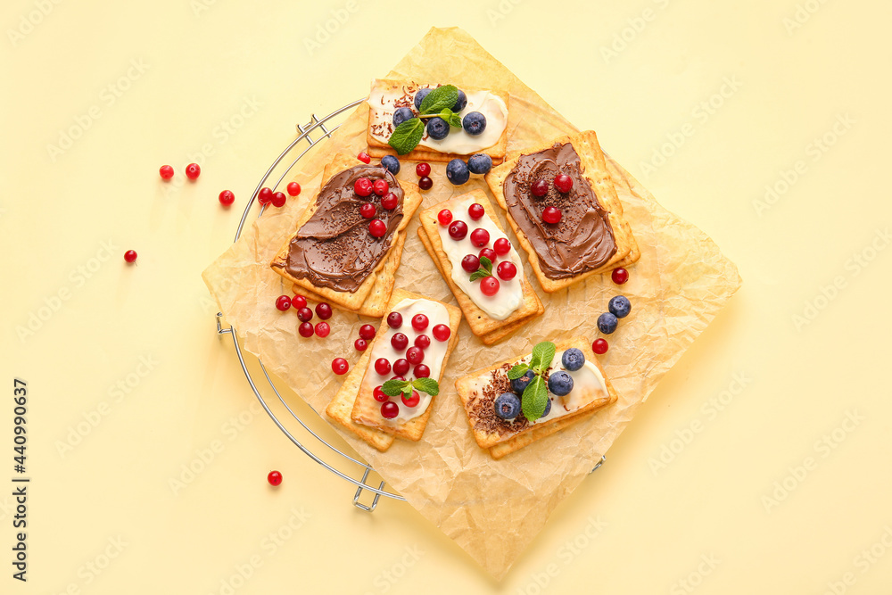 Tasty crackers with berries on color background
