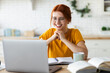 © kucherav - Online learning, portrait of red-haired happy caucasian female freelancer or smiling woman student using a laptop for a video call with a teacher, distance education concept