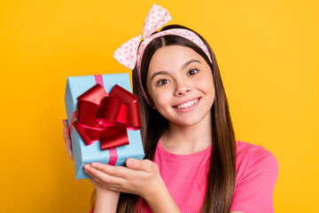 Sticker - Photo of cute sweet small schoolgirl dressed pink t-shirt holding present box smiling isolated yellow color background