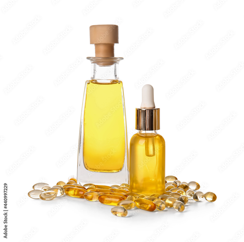 Bottles of fish oil and capsules on white background