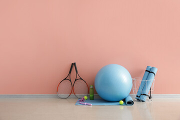 Wall Mural - Set of sports equipment with fitness ball on color background