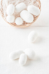 Wall Mural - white silkworm cocoons shells, source of silk fabric in the basket on table with copy space