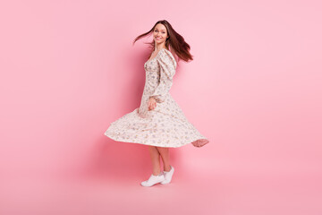 Full length body size photo pretty girl dancing smiling happy wearing floral dress isolated pastel pink color background