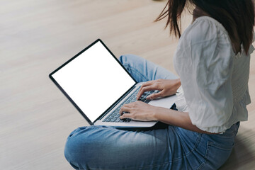 Image young woman working on the floor using a laptop blank white screen at the office. Mock up.