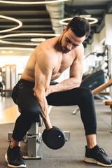 Poster - Handsome young sporty male bodybuilder doing exercise with dumbbells in the gym