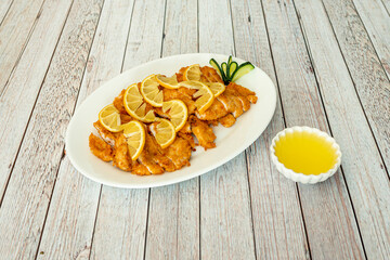 Wall Mural - Tray of sliced breaded chicken breast fillets and Chinese recipe lemon juice and sauce