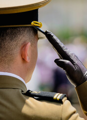 Shallow depth of field (selective focus) details with a young Romanian soldier saluting during a ceremony.