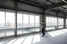 Professional Man On Phone In Empty Warehouse