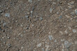 Stony desert soil texture. Gray dry ground with small stones. Close-up from above