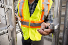Close Up Male Warehouse Worker With Padlock At Gate