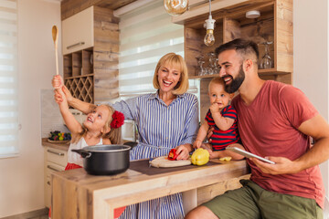 Wall Mural - Parents having fun cooking dinner with their children