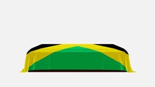 Side View Of A Casket On A White Background Covered With The Country Flag Of Jamaica