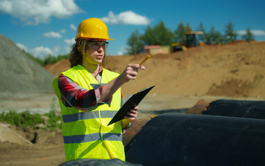 building contractor counting number of pipes on the construction site.