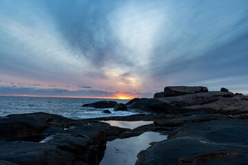 Wall Mural - Gorgeous shot during the sunset with the orange light on the background of seawater and the shore