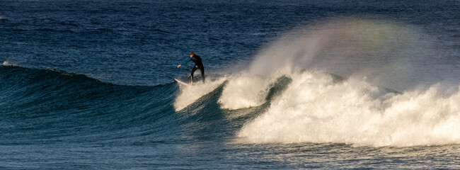 Poster - Beautiful shot of a person surfing on the blue powerful seawater waves