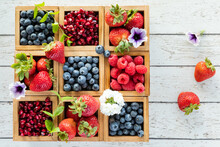Various Berries In Wooden Boxes On A Rustic Wooden Table With Copy Space To The Right.
