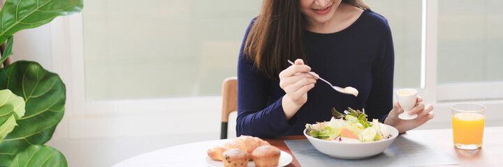 Portrait of happy playful asian girl eating fresh salad in diet concept