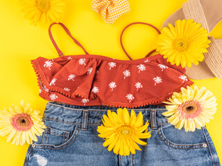 Wall Mural - Summer holiday fashion outfit with straw sandals, swimsuit top, jeans shorts and flowers on yellow