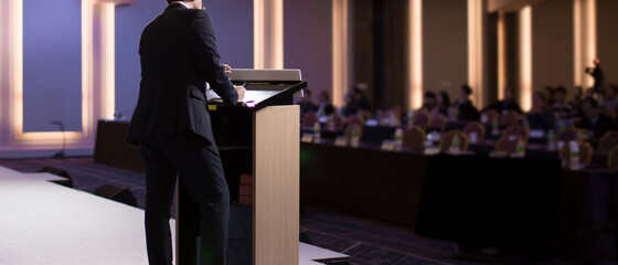 Fototapete - Conference photo audience and speaker giving speech. Seminar presenter on a panel during forum. Corporate manager in sales executive training discussion on stage. Investor pitch presentation.
