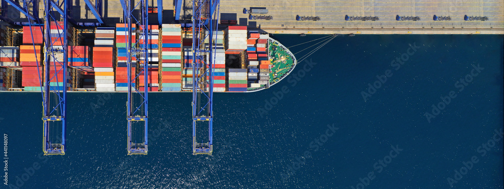 Aerial top down ultra wide photo of industrial container ship loading  - unloading colourful truck size containers with cranes in logistics terminal port - obrazy, fototapety, plakaty 