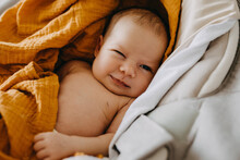Closeup Of A Newborn Baby Making Funny Face, Winking And Smiling.