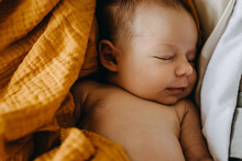 Closeup Of A Newborn Baby Dreaming And Smiling While Sleeping.